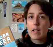 Maia Kobabe holds up a copy eir graphic memoir Gender Queer during an interview