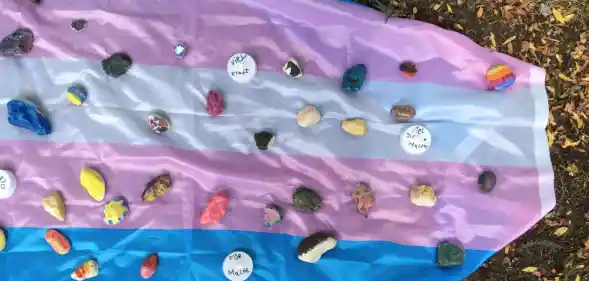 A memorial placed on a trans Pride flag after a young trans man was attacked in Münster, Germany