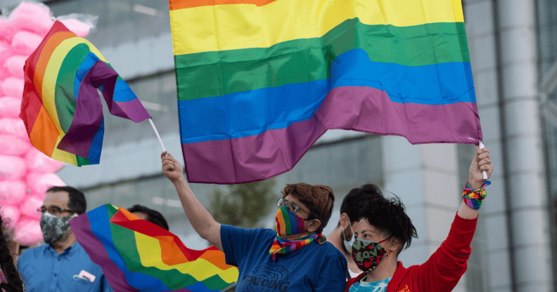 A crowd of people in Chile wave LGBTQ+ Pride flags