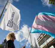 An activist holds a transgender pride flag at a protest by Transgender Action Block and supporters outside the first annual conference of the LGB Alliance