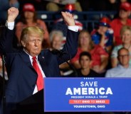 Donald Trump waves his small arms in the air at a Save America Rally