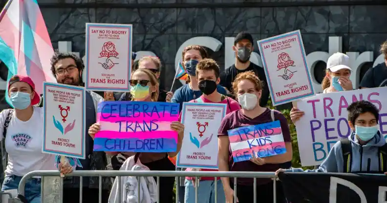 A group of LGBTQ+ activists hold banners promoting trans rights at Boston Children's Hospital where a bomb threat was made a few weeks ago