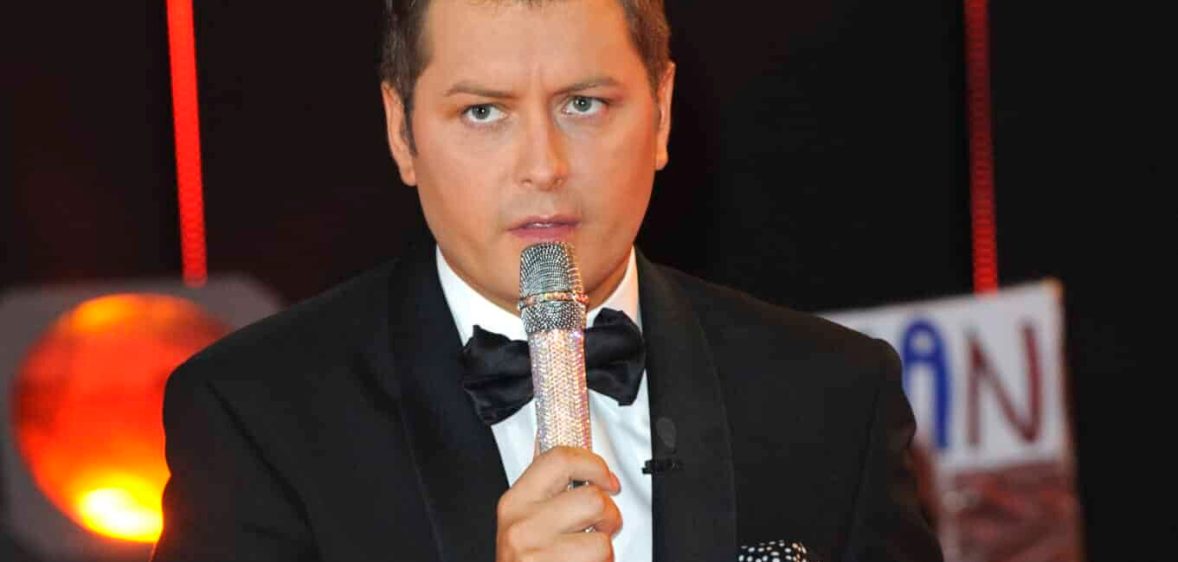 Brian Dowling holds a microphone