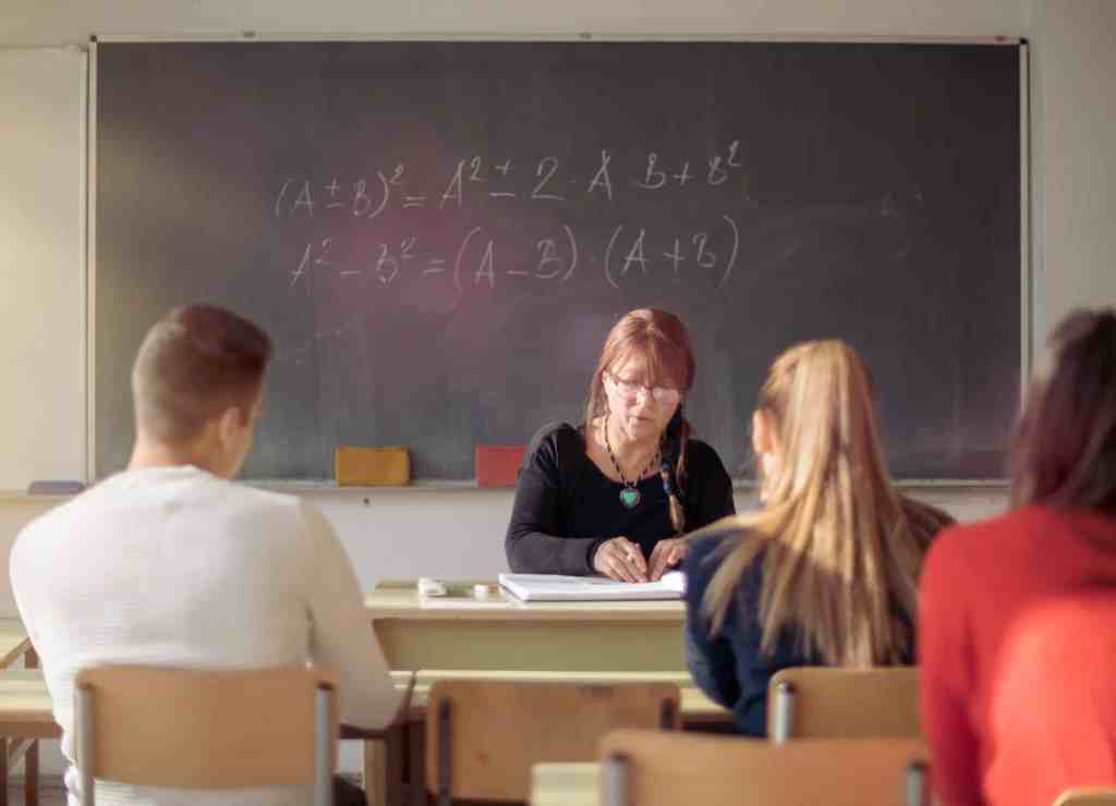 Teacher and students in high school classroom.