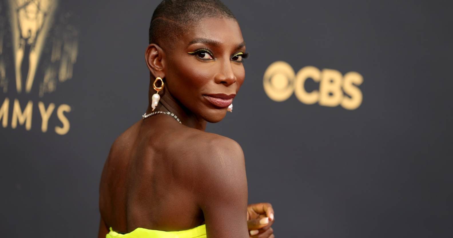 A photo shows actor Michaela Coel wearing a bright yellow dress as she poses for the camera at a red carpet event . (Getty)