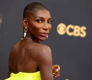 A photo shows actor Michaela Coel wearing a bright yellow dress as she poses for the camera at a red carpet event . (Getty)