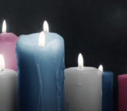 Lit candles in the colours of the trans Pride flag