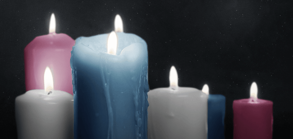 Lit candles in the colours of the trans Pride flag