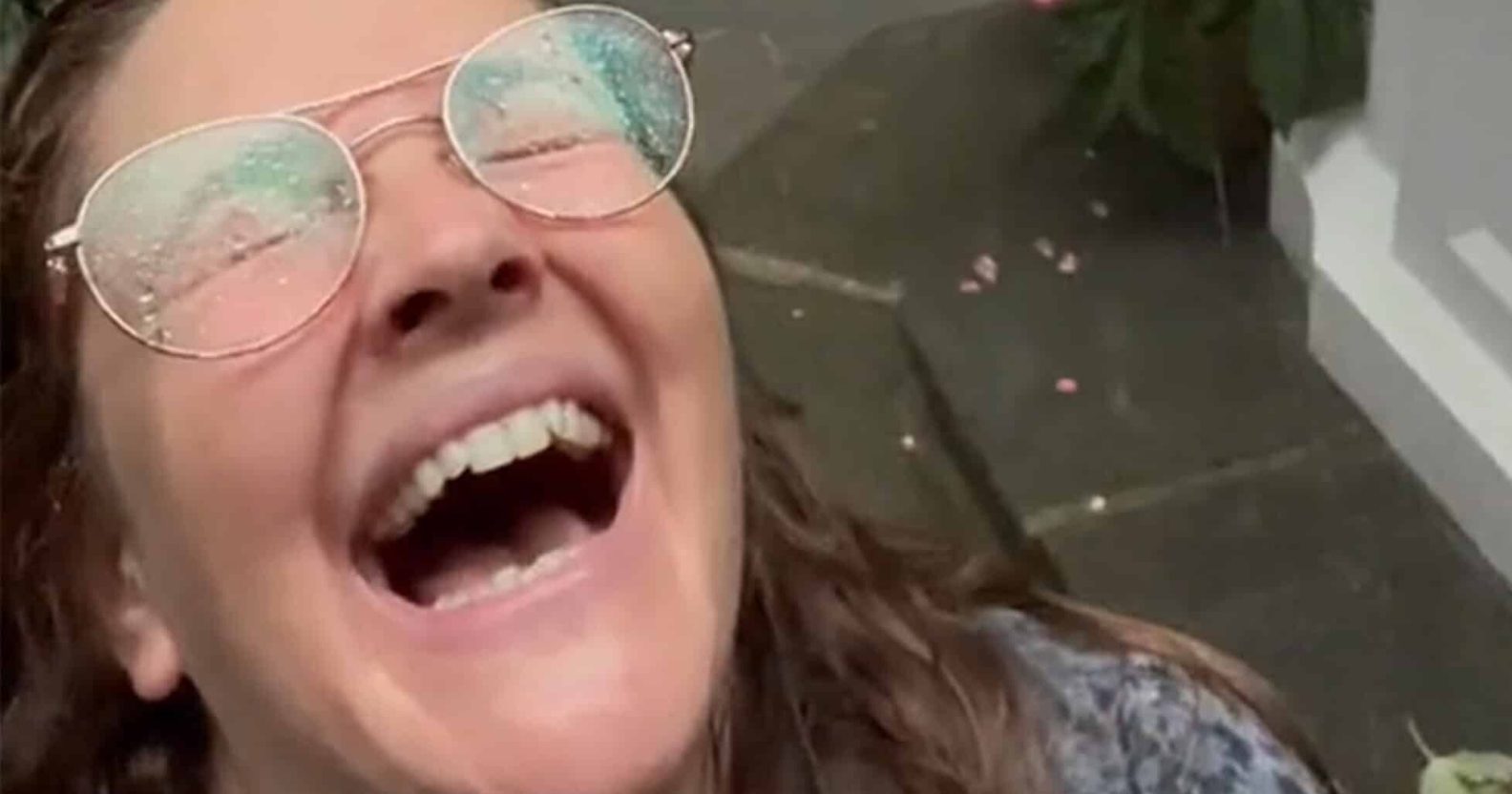 A screenshot from a viral TiKTok of Drew Barrymore frolicking in the rain