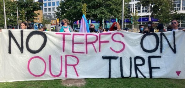 Pro-trans protestors hold a banner reading no terfs on our turf