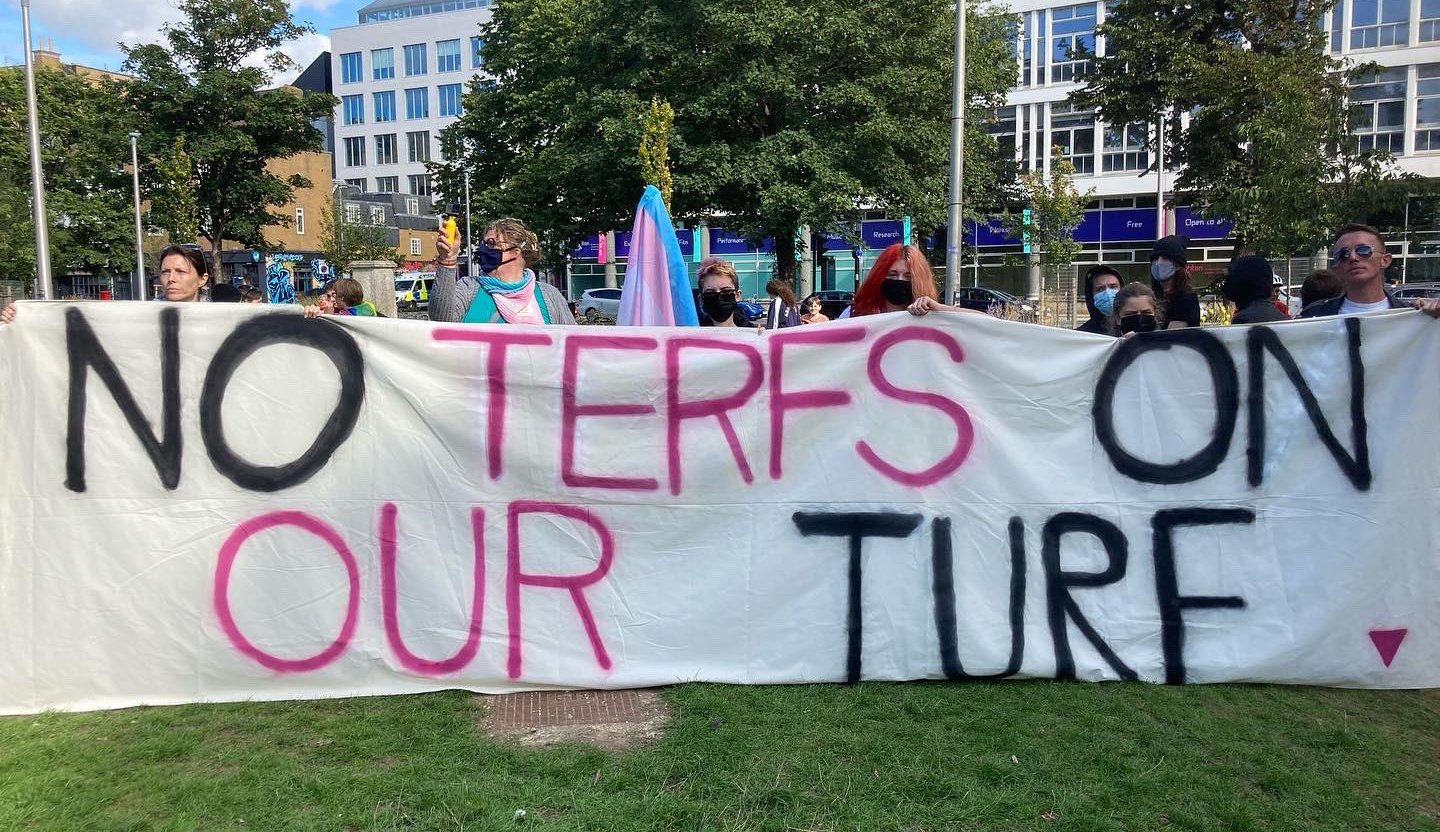 Pro-trans protestors hold a banner reading no terfs on our turf