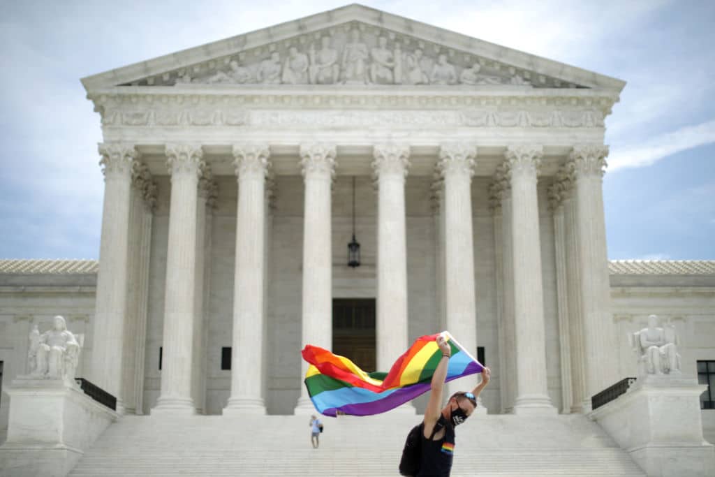 Joseph Fons holding a Pride Flag, walks back and forth in front of the U.S. Supreme Court