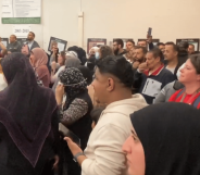 An image from Twitter shows protestors in the Dearborn School Board Meeting