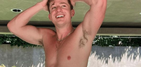 Charlie Puth, topless, with his arms above his head