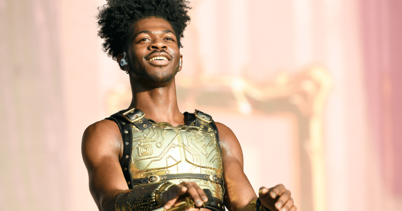 Lil Nas X wears a golden plated top as he performs on stage during a concert