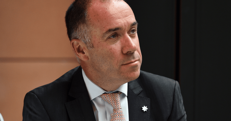 Andrew Thorburn wears a suit as he stares somewhere off camera