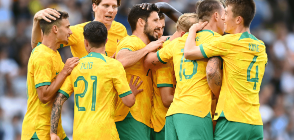 Players from the Australia national football team, known as the Socceroos, huddle together in a match. Several players from the team released a statement denouncing Qatar's human rights record ahead of the World Cup in November