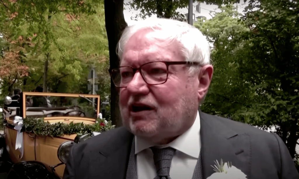 Gay former monk Anselm Bilgri wears a suit as he talks to someone off camera after his wedding
