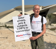 A photo of Peter Tatchell in Qatar holding his LGBTQ+ placard during his protest