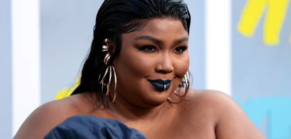 Lizzo wears a blue outfit as she poses for a photo at an event