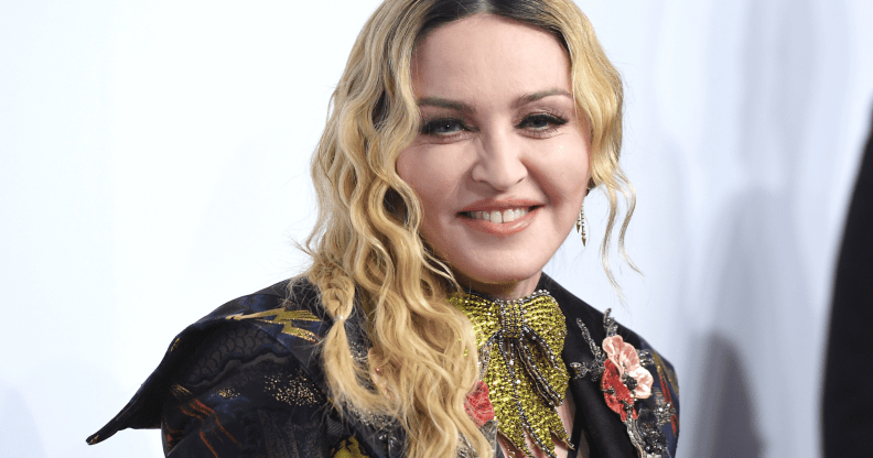 Madonna wears a sparkly green tie necklace with an embroidered outfit