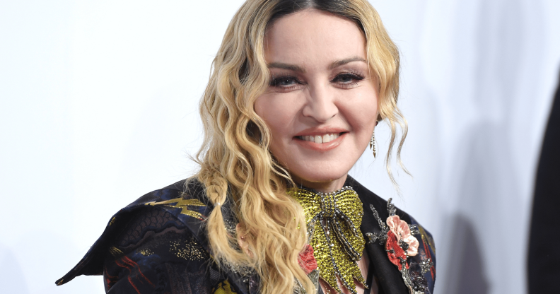 Madonna wears a sparkly green tie necklace with an embroidered outfit