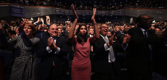 People stand and applaud during a speech at the Conservative Party conference