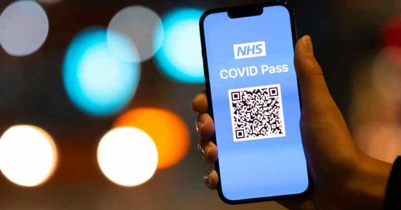 A woman holds an Apple iPhone showing a NHS Covid Pass on October 8, 2021.