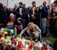 People attend the vigil in Slovakia, placing Pride flags and candles, following the shooting where two men were killed