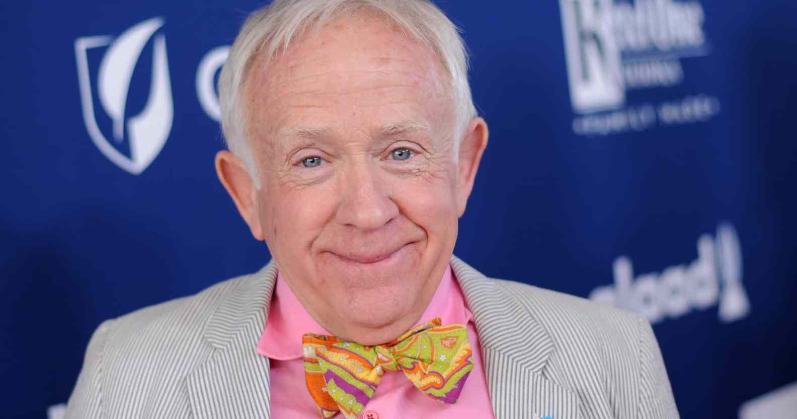 An image of late actor Leslie Jordan wearing a grey suit jacket, pink shirt and yellow and pink bow tie