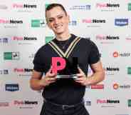 Matt Bernstein smiles with his award at the PinkNews Awards 2022 event. (PinkNews)