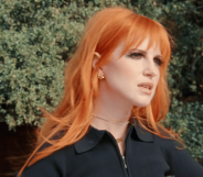 Hayley Williams standing in front of trees