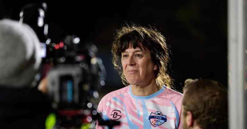 A photo of trans woman Paula Griffin in front of a camera after playing a match with her women's football team