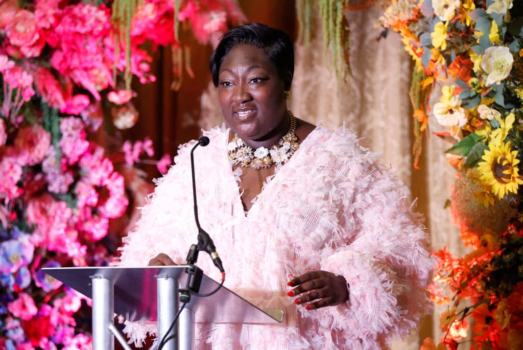 A photo of Phyll Opoku-Gyimah wearing a pink dress as she speaks at the Kaleidoscope Trust Gala dinner