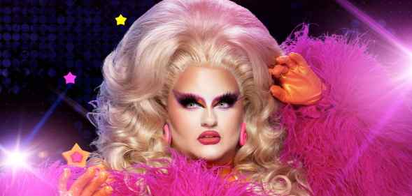 A promotional photo of Victoria Scone in full pink drag outfit with spotlight graphics shining in the background