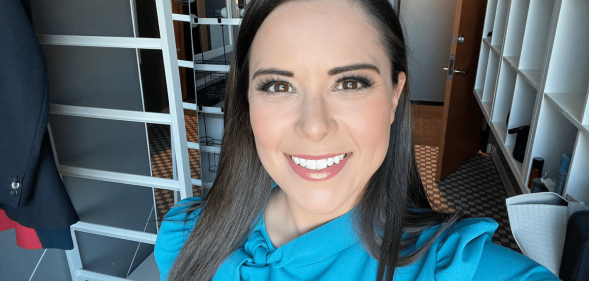 A Twitter screenshot of TV anchor Ashley Michels wearing a light blue top and smiling as she takes a selfie in the green room of KWGN news set.