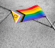 The progress Pride flag lying on the pavement
