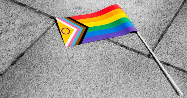 The progress Pride flag lying on the pavement