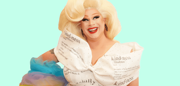 Drag Race queen Nina West wears a white dress with type on it and with rainbow coloured details