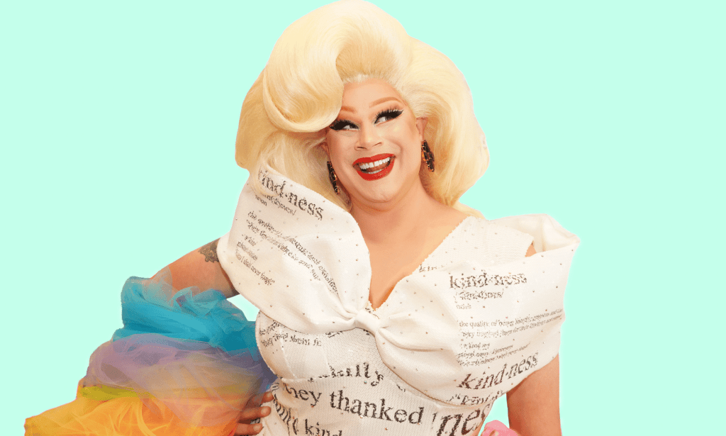 Drag Race queen Nina West wears a white dress with type on it and with rainbow coloured details