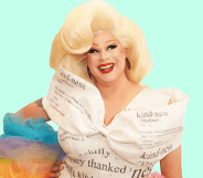 Drag Race queen Nina West wears a white dress with type on it and with rainbow coloured details