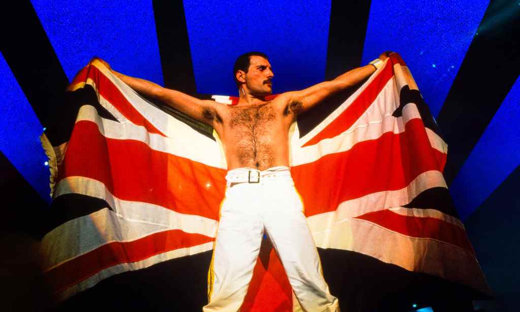 Freddie Mercury holding up a Union Jack on stage.