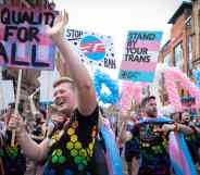 Picture showing people holding pro-trans placards as they march at a trans Pride parade in Manchester