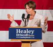 A photo of Democrat Maura Healey standing in front of the American flag as she talks into a microphone during her acceptance speech