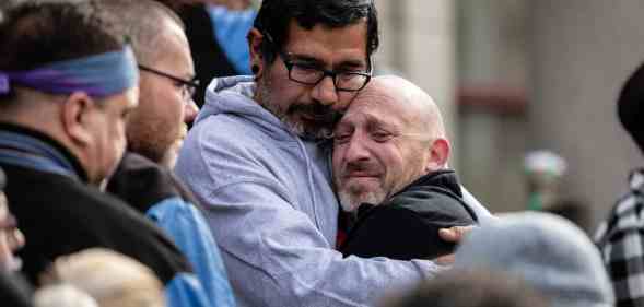 Club Q co-owner Nic Grzecka is embraced by mourners outside of the Colorado Springs City Hall.