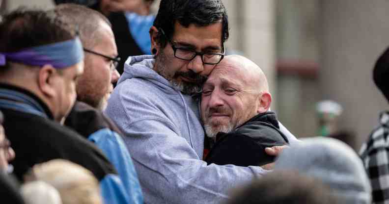 Club Q co-owner Nic Grzecka is embraced by mourners outside of the Colorado Springs City Hall.