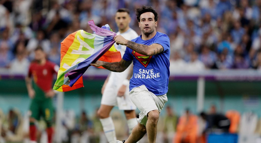 Heroic activist Mario Ferri Falco runs onto the pitch holding a rainbow Pride flag on 28 November during the World Cup match between Portugal v Uruguay at the Lusail Stadium in Qatar