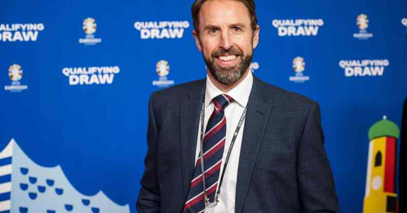 England manager Gareth Southgate wearing a navy coloured suit jacket and tie over a white shirt smiles to the camera at the UEFA Euro 2024 Qualifying Group Stage Draw - Ceremony
