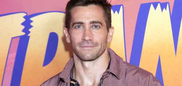 Jake Gyllenhaal infront of a logo of the Disney film Strange World