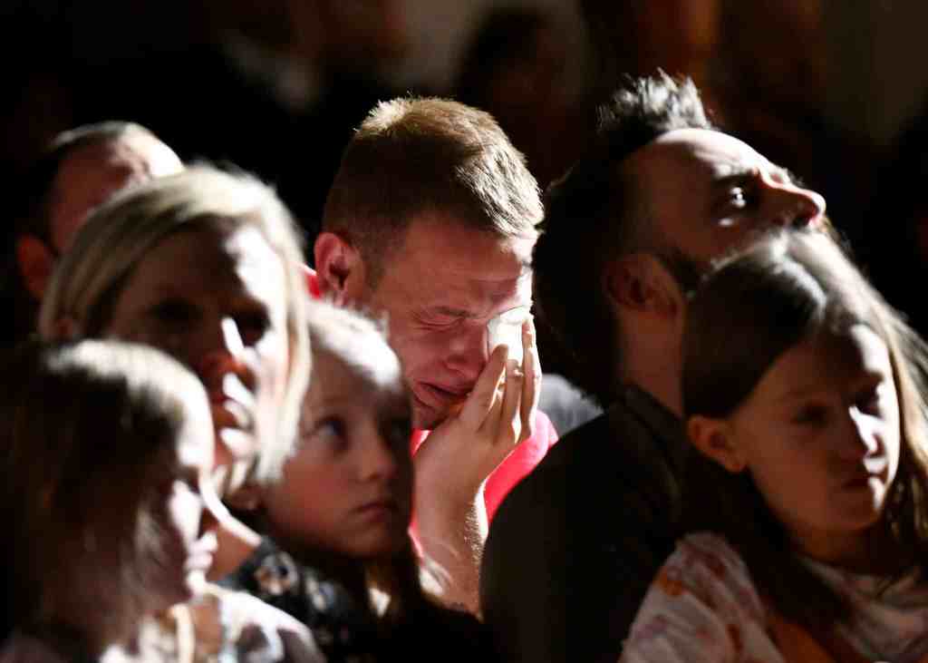 A scene from the vigil inside All Souls Unitarian Church in downtown Colorado Spring shows a man crying